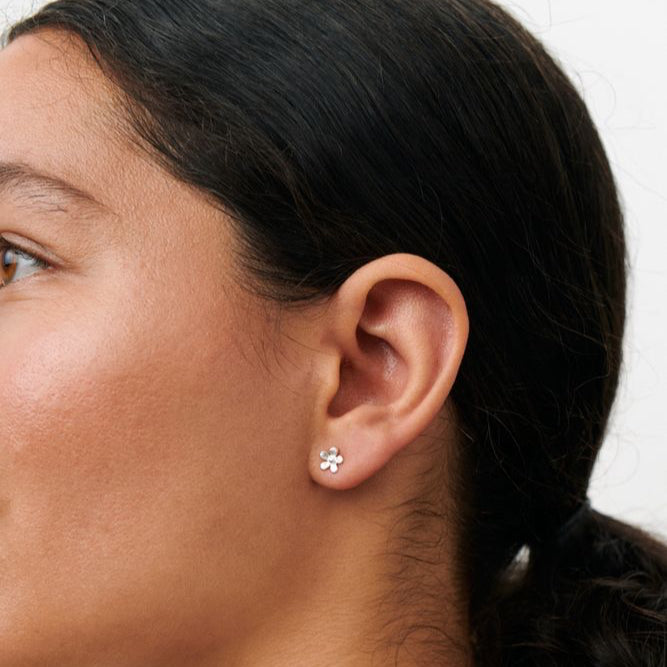 Pernille Corydon Mini Wild Poppy Stud Earrings shows a silver flower shaped earring on model. Model E-369-S