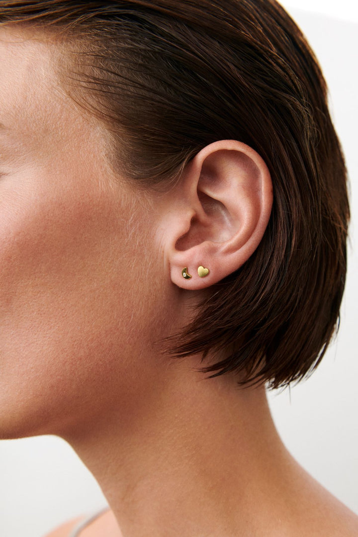 Pernille Corydon Night Light Earsticks are shown on ear, small gold-plated earsticks in a minimalist design. Model C-122-GP-2