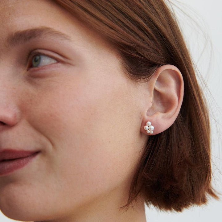 Pernille Corydon Ocean Bay gold plated pearl earrings worn close to the ear, feminine white pearls. Model E-442-GP-2.