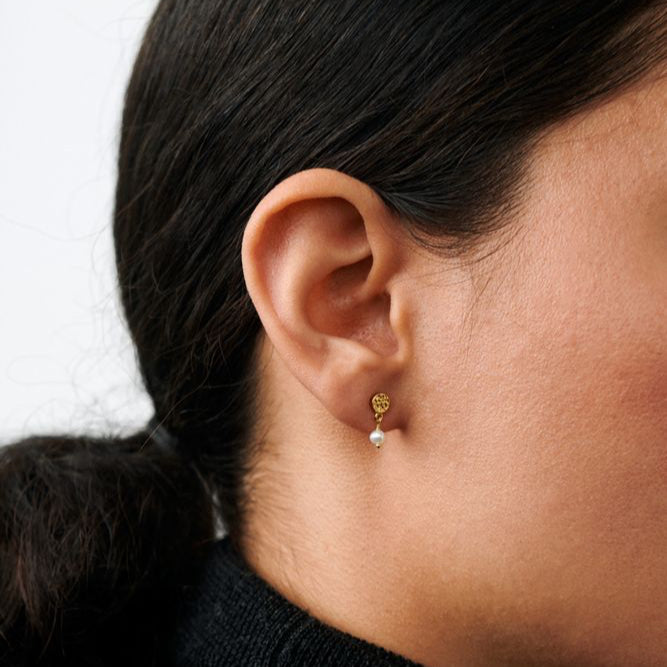 Pernille Corydon Ocean Nature Earrings in gold-plated silver with a small pearl, worn by a woman. Model E-394-GP-1
