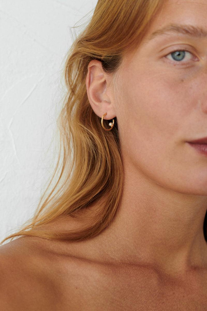Pernille Corydon Pearl Globe Hoops in gold plated silver shown on ear, elegant and simple style. Model E-404-GP