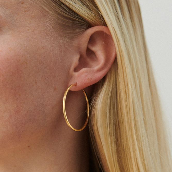 Pernille Corydon Small Orbit Hoops gold plated worn on ear, slim round golden earring. Model E-052-GP.