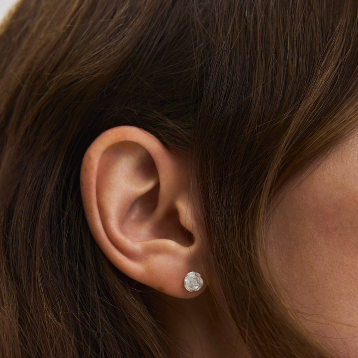 Pernille Corydon Small Rose stud earrings in silver, round shiny earring on ear, Model E-535-s