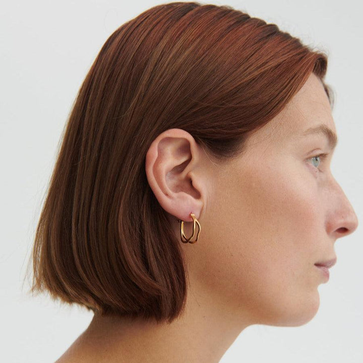 Pernille Corydon Stream Hoops in silver, elegant hoops shown on woman with short hair. Model e-459-s-2