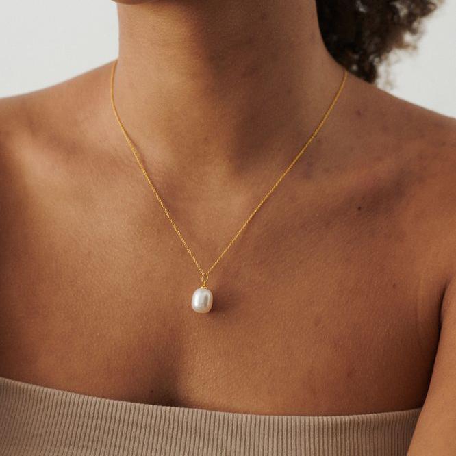 Pernille Corydon Treasure gold plated necklace with pearl pendant is displayed on neck. Model N-445-GP