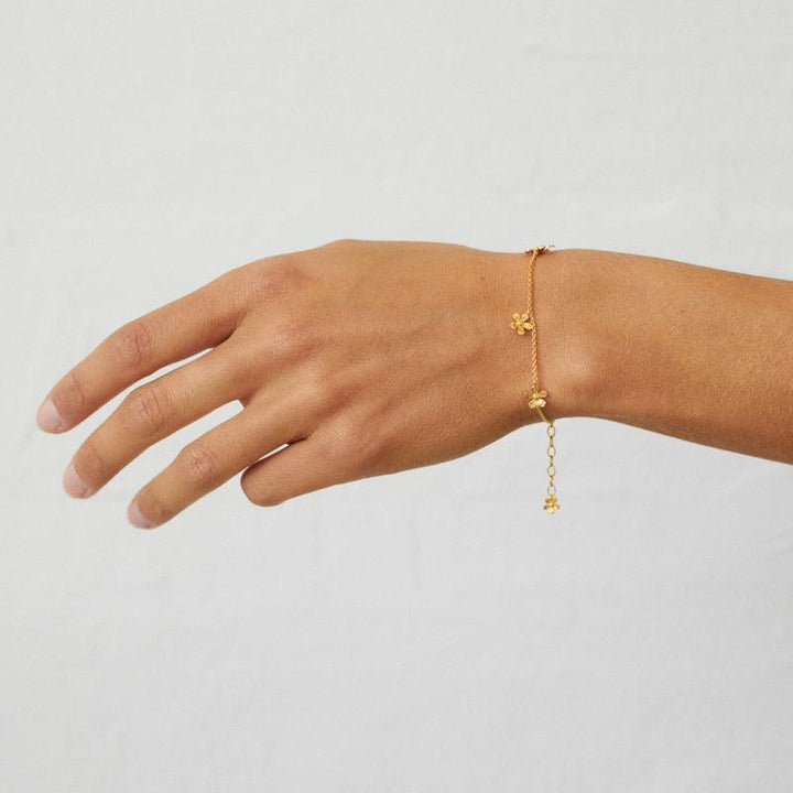Pernille Corydon Wild Poppy Bracelet in gold plated silver shown on hand with simple chain and floral details. Model B-363-GP