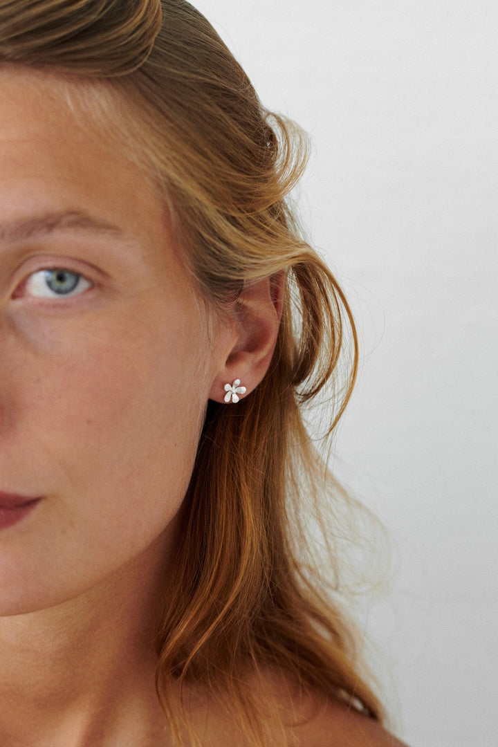 Pernille Corydon Wild Poppy earrings in silver can be seen on the model's ear, elegant floral design. Model E-362-S