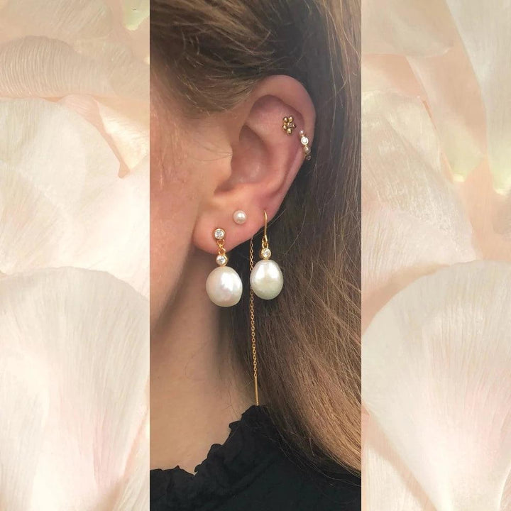 Isla Stud shows an ear with multiple earrings in gold and pearls, in a feminine and elegant look. Model fw2304-2