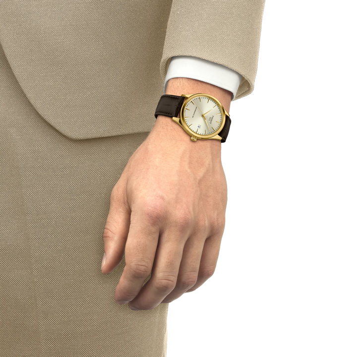 Tissot Classic Dream Powermatic 80 gold PVD with brown leather strap worn on wrist, Model T1584073626100