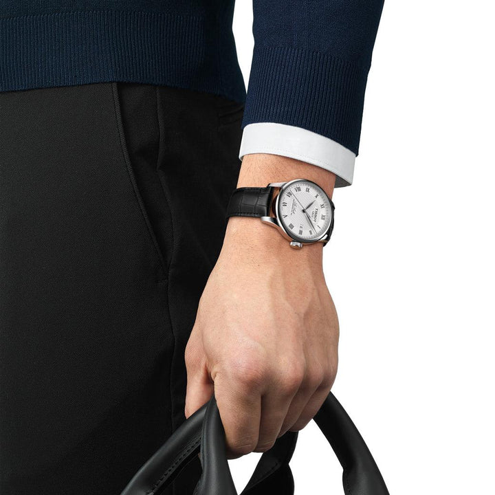Tissot Le Locle Powermatic 80 men's watch with silver dial and black leather strap on the man's hand. Model T0064071603300