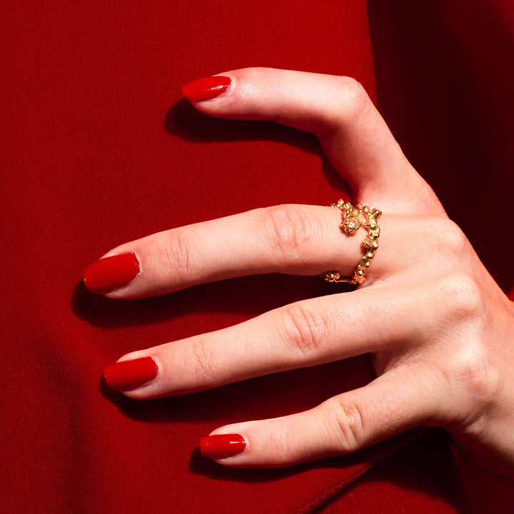 Vincent Adagio Spin Gold Plated Ring shown on hand with red nails, detailed gold texture. Model VJ214-URG-001.