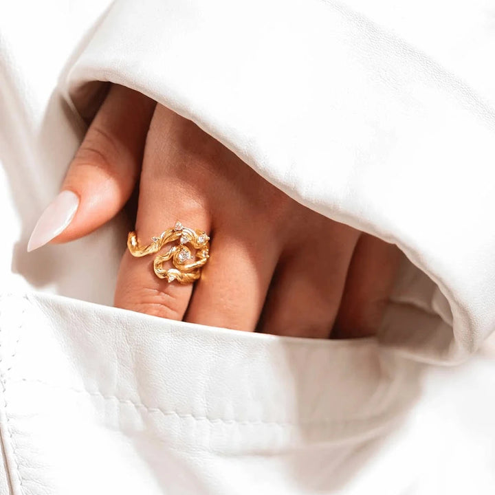 Vincent Aurum Roots Ring gold-plated with white crystals displayed on hand, elegant nature-inspired design. Model VJ251-URG-001