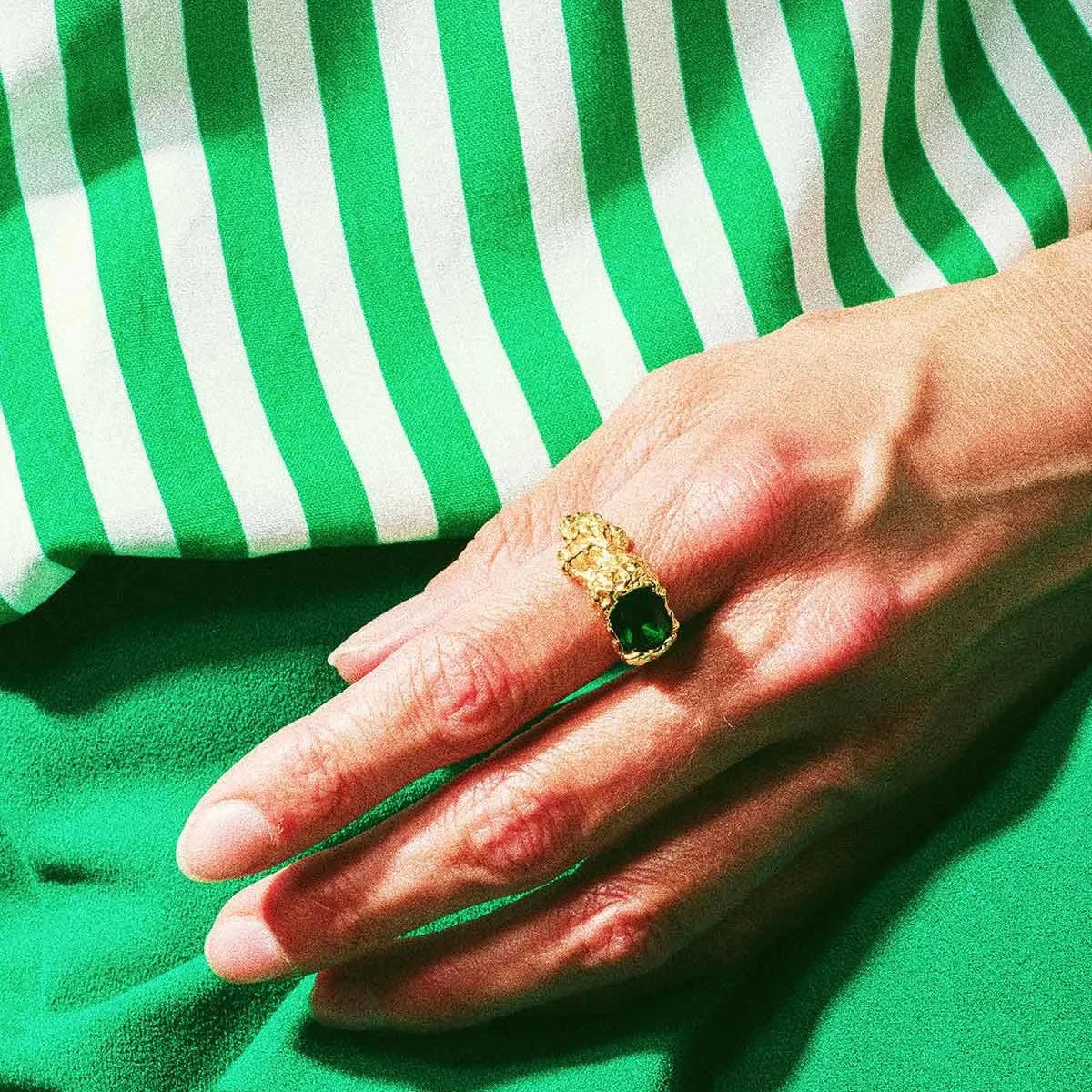 Vincent Stolen Possession Ring gold-plated ring with large green stone, worn on hand. Model VJ103-URG-001