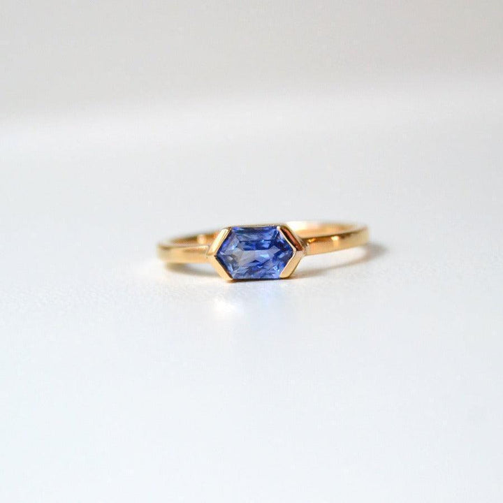 Anpe Atelier Customized Ring with blue sapphire shown close up, elegant in gold with hexagonal blue sapphire stone. Model 27-blasafir-001-1