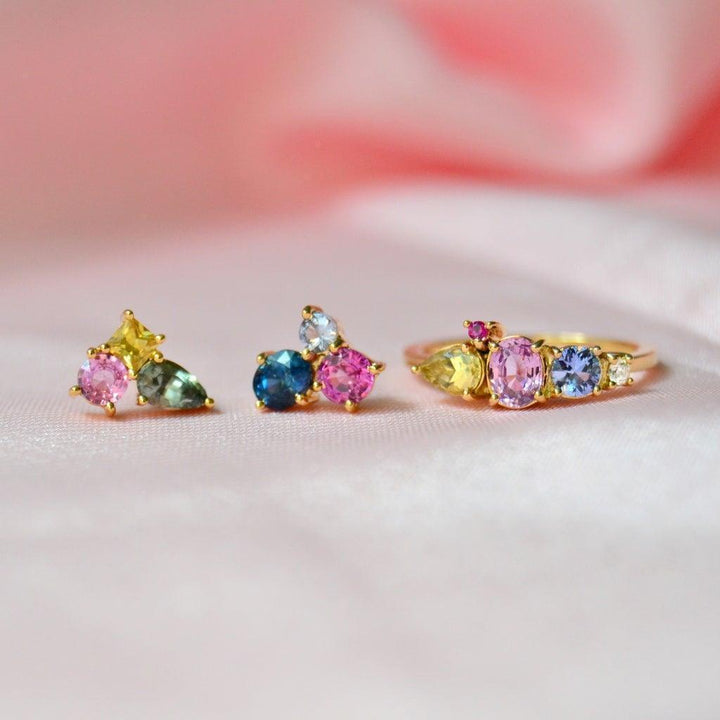 Anpe Atelier Varnaya 18kt gold ring with sapphires shown on front on pink fabric. Model 27-customized2-001-2