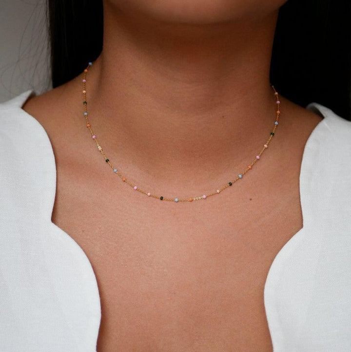 enamel lola necklace n55g dreamy appears on a neck, with small colored pearls and gold colored chain. Model n55g-dreamy-2