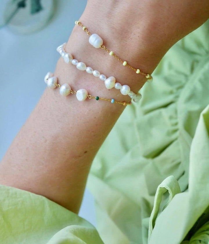 enamel pearlie bracelet with freshwater pearls and gold details, worn on a woman's arm. Model B79G-B79G-2