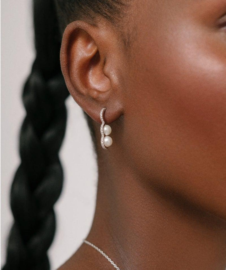 Heriteth Paul x Polar Jewelry Bahati Silver Earring shows pearl studded silver earring worn on ear, Model bah-hs-sl-wp-wz-00502-2.
