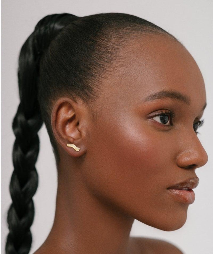 herieth-paul x polar jewelry 22kt gold plated earring seen on model, elegant golden detail. Model: UTU-ST-GD-WZ-00510