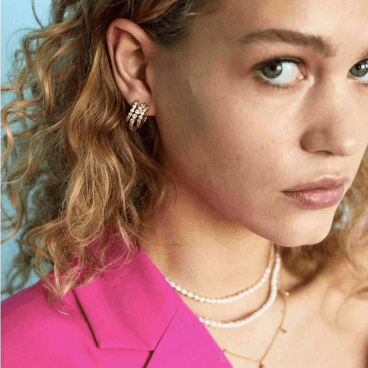 Hultquist Copenhagen Amara Mini Earrings are shown worn in the ear, gold look with clear stones. Model S08149G.