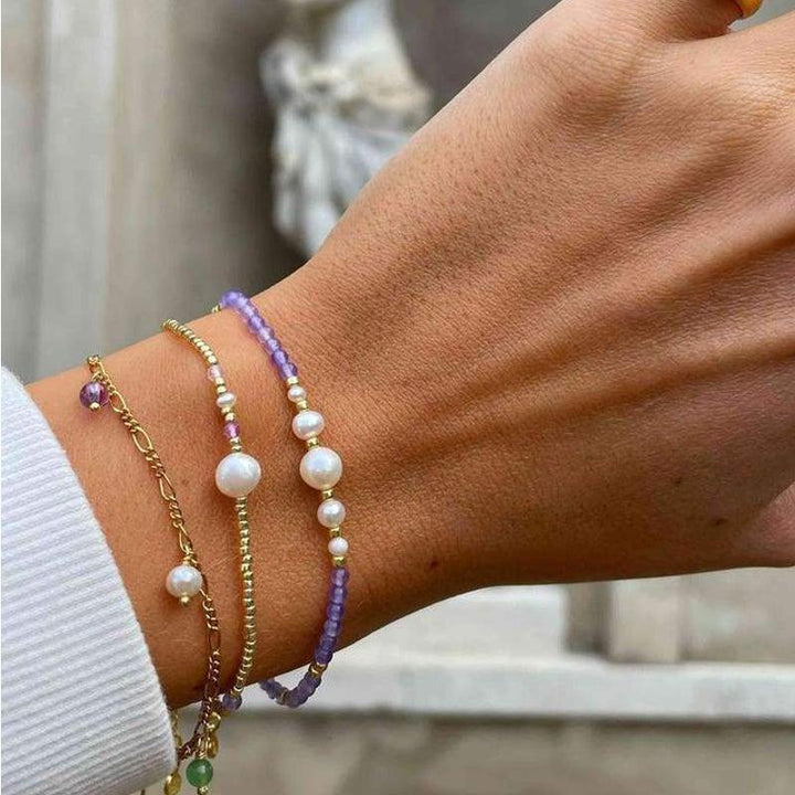Hultquist Copenhagen Maya Bracelet with purple pearls and gold details is worn on the wrist. Model S08105G