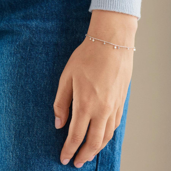 Pernille Corydon Glow Bracelet shows a silver colored bracelet with small pendants on the model's hand. Model B-018-S