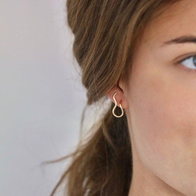 Ro Copenhagen 18kt Fryd Wave Earring Right shown on ear, elegant wavy gold earring. Model 108103-2