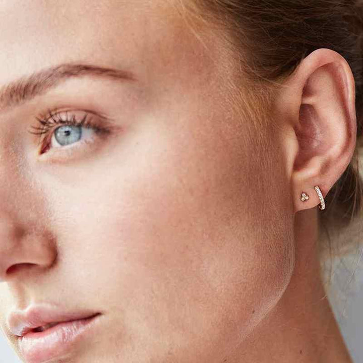 Ro Copenhagen 18kt Orbit Dot stud earrings shown on ear, elegant design in gold with small diamonds. Model 119120-2