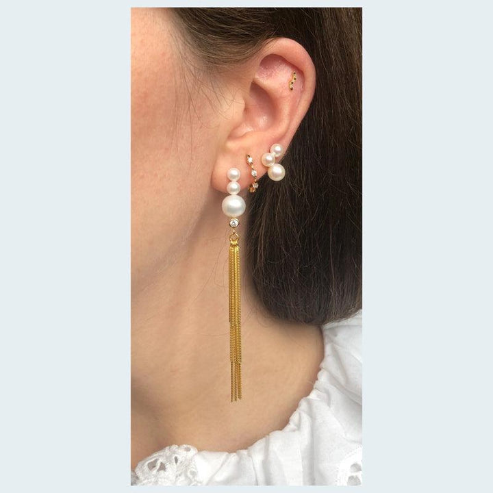 Belle Earrings with pearls, elegant earring in gold and white pearls worn on a woman's ear. Model FW2005.